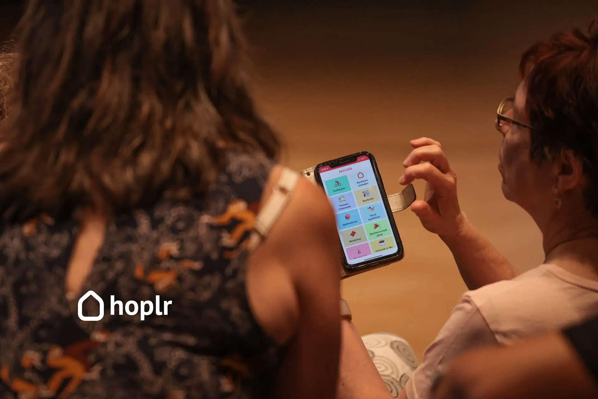 Eine Frau sieht sich die Hoplr-App auf ihrem Smartphone an.