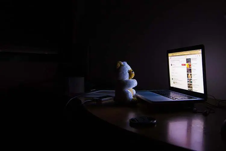 teddybeer voor computer in een donkere kamer